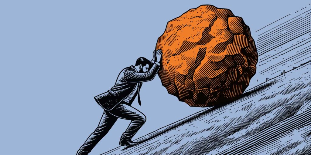 ein Mann schiebt eine Kugel den Hügel hoch